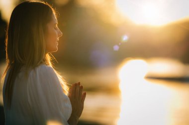 Göl kenarında meditasyon yapan kadın. Dua Konumu.  