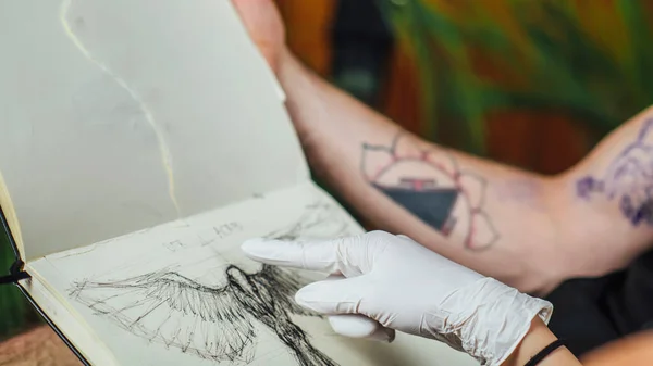 Γυναίκα Καλλιτέχνης Τατουάζ Δείχνει Σχέδιο Τατουάζ Στον Πελάτη — Φωτογραφία Αρχείου