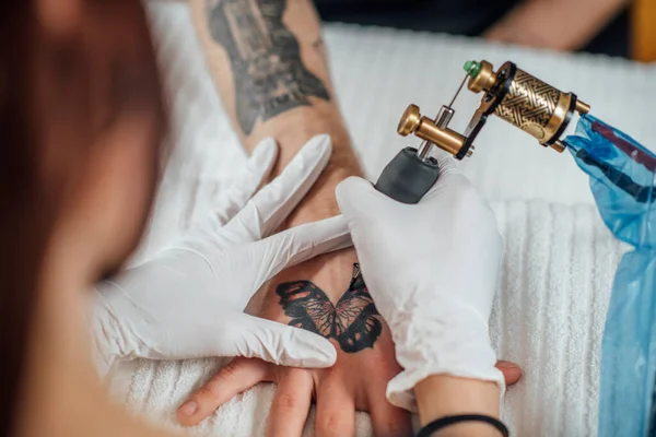 Professionell Kvinnlig Tatueringsmästare Tillämpa Tatuering Hand Ung Man Med Tatueringsmaskin — Stockfoto