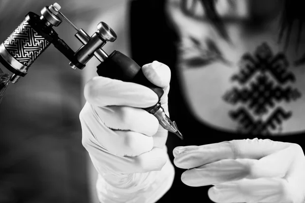 Tattoo machine close up. Tattoo artist creating tattoo on a man\'s arm