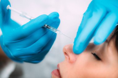 Deri dolguları tedavi görüyor. Deri doldurucu yüz enjeksiyonları için kadınların burun köprüsünü şekillendiren doktor.. 
