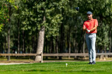 Genç golfçü golf oynamaya hazırlanıyor.