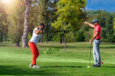 Çiftler için golf tatili, güneşli bir havada golf oynamak.