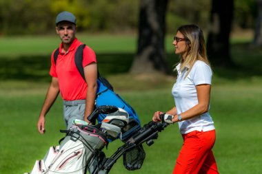 Golf sahasında eğlenen bir çift.