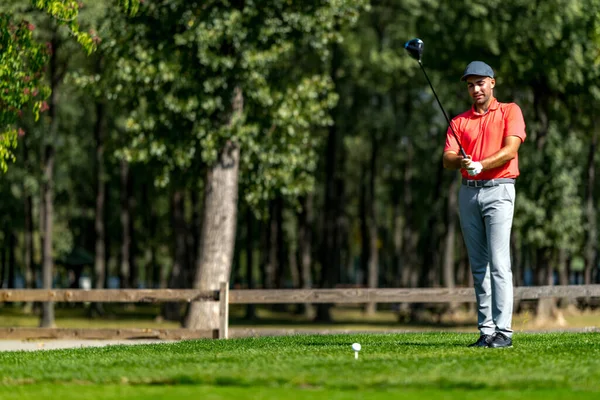 Genç golfçü golf oynamaya hazırlanıyor.