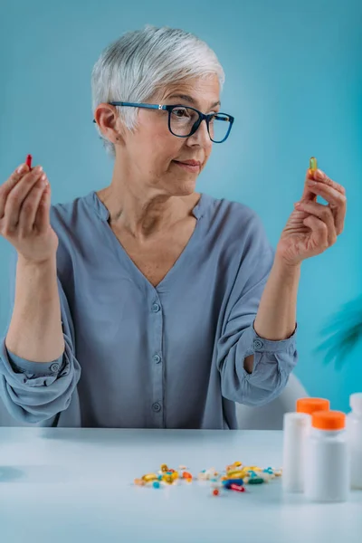 Confused Senior Woman Looking Her Medicines Table Medicine Non Adherence —  Fotos de Stock