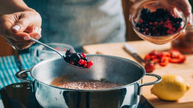 Meyve konservesi muhafazası. Kadın meyve pişiriyor ve ev yapımı reçel yapıyor..