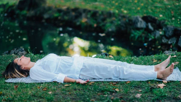 死体の位置 サヴァサナ ヨガを練習し 水で瞑想若い女性 — ストック写真