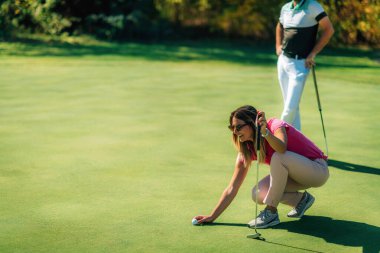 Genç çift golf sahasında güzel bir sonbahar gününün tadını çıkarıyor.