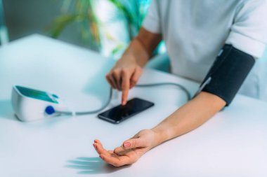 Woman Measuring Blood Pressure at Home 