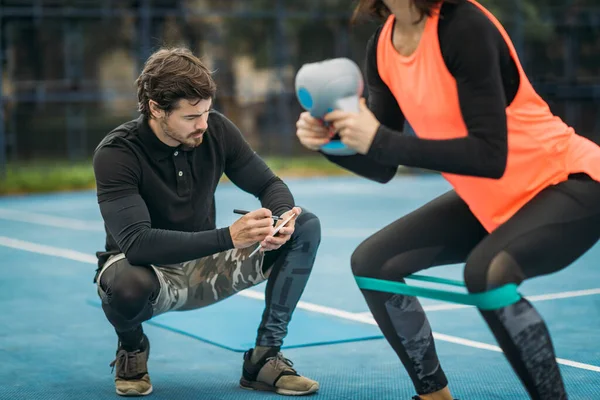 Osobní Fitness Trenér Pracuje Mladou Ženou Dělá Kettlebell Cvičení Venku — Stock fotografie