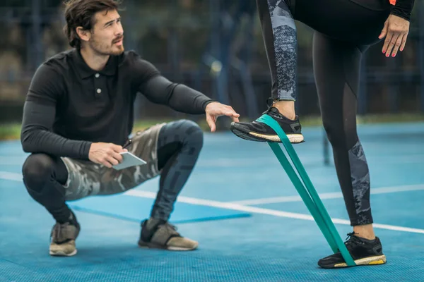 Personal Fitness Trainer Coaching Young Woman Doing Resistance Band Exercises — Foto de Stock