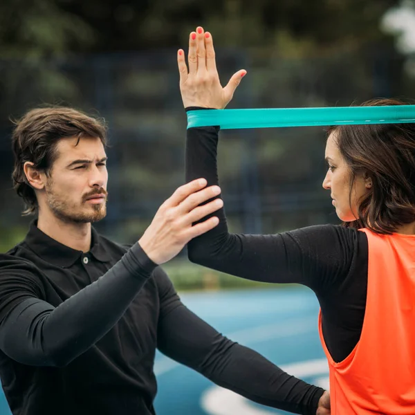 Personal Fitness Trainer Coaching Young Woman Doing Resistance Band Exercises — Foto de Stock