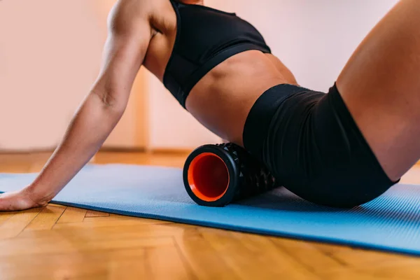 Female Athlete Stretching Lower Back Muscles Foam Roller Home — Zdjęcie stockowe