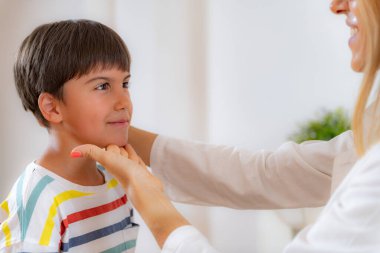 Pediyatrist oğlanla gelişim muayenesi yapıyor. Duruş kontrol ediliyor.