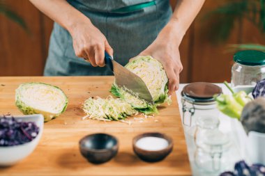 Fermantasyon süreci. Kadın evde fermantasyon için sebze hazırlıyor. Lahana kesmek ve kavanoza koymak..