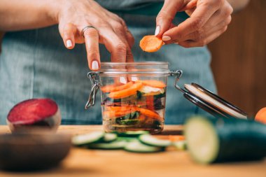 Fermantasyon süreci. Kadın evde fermantasyon için sebze hazırlıyor. Salatalık ve pancar kesmek.