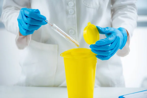 Medical Waste. Throwing Away Mouth Swab in Container for Hazardous Medical Waste.