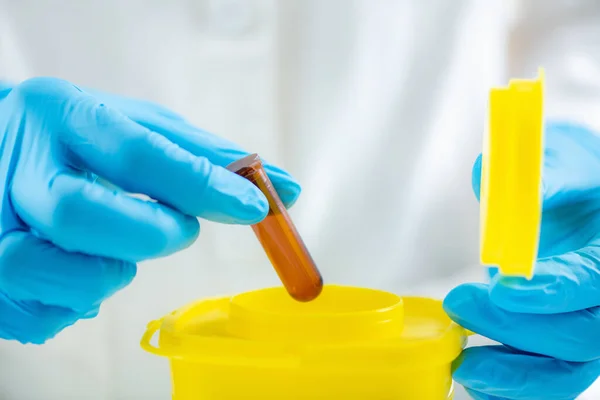 Medical Waste. Throwing Away Laboratory Consumables in Container for Hazardous Medical Waste.