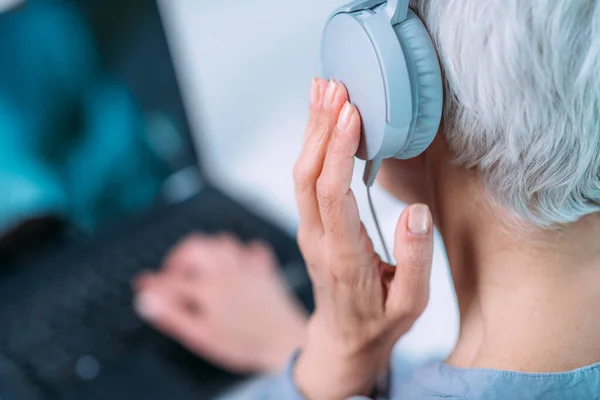 Hearing test or audiogram. Senior woman self-testing hearing ability with laptop