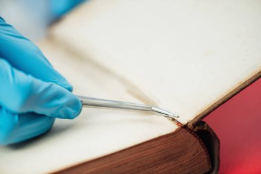 Old book restoration. Conservator repairing antique book in restoration laboratory