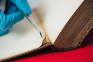 Old book restoration. Conservator repairing antique book in restoration laboratory