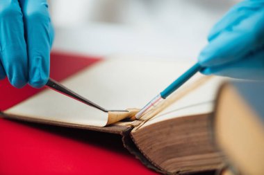 Antique book restoration. Book restorer repairing damaged pages in an antique book