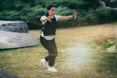 Qi Gong energizing exercise outdoors.