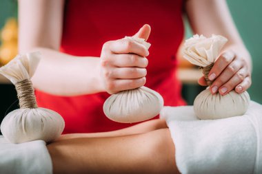Kizhi masajı ya da bitkisel bolus torbaları Ayurveda masajı, bir Ayurveda masaj terapistinin elleri hastaların cildine bitkisel bolus torbaları bastırıyor. 