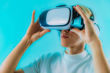 Sanal gerçeklik kulaklığı olan bir kadın meta-evren dünyasını keşfediyor. Mavi kopyalama alanı