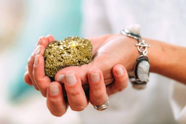 Bolluk konsepti. Ruhani bir öğretmenin elleri, değerli, doğal, parlak metal bir nesne tutuyor, insanların hayatta bolluk yaratma yeteneklerine odaklanmalarına yardım ediyor..