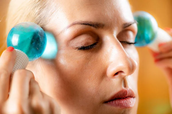 Woman doing facial self-massage with ice balls