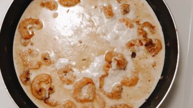 Karidesler tavada kızartılır. Kremalı soslu ve soğanlı karidesli makarna hazırlıyorum. Karidesler krema ve sütle pişirilir..
