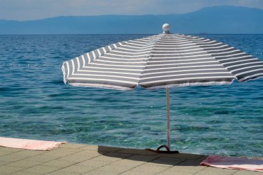 Hırvatistan 'ın Krk adasının uzak sahillerinde çizgili şemsiye