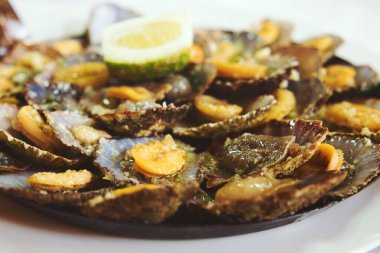 Madeiran spesiyalitesi olan limpet lapaları kendi kızartma tavalarında pişirilir. Taze limon ve tereyağı sürüldüğünde tadı artar.. 