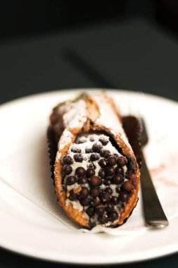 Classic Sicilian cannoli - crisp tubes of golden-brown fried dough filled with a creamy ricotta, candied fruit, and chocolate filling