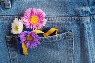 Stand with Ukraine and pray for peace - blue and yellow symbol of Ukrainian patriotism in pocket with flowers