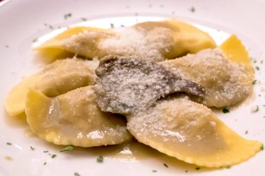 Parmesan peynirli ev yapımı İtalyan mantısı, kıymalı somon filetosu, ricotta ve otla servis edilir.