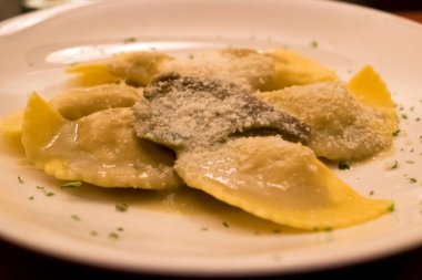 Parmesan peynirli ev yapımı İtalyan mantısı, kıymalı somon filetosu, ricotta ve otla servis edilir.