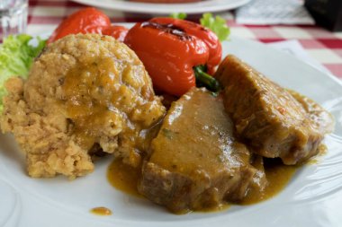 Geleneksel Slovenya yemeği - Geleneksel Avusturya usulü acı sosta pişirilmiş domuz bifteği ve ızgara sebze ve patates püresi ile servis edildi