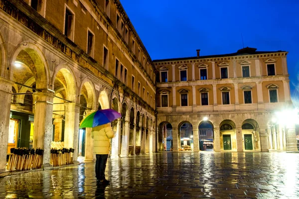 A lonely person dreaming on the old square of Venice, Italy, on rainy evening