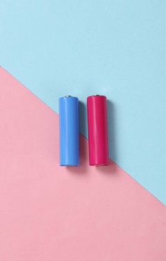 Mavi pembe arka planda AA piller. Minimalizm