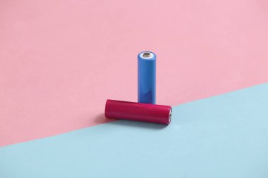Mavi pembe arka planda AA piller. Minimalizm