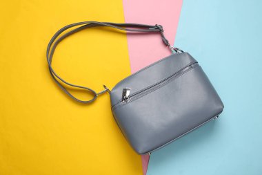 Renkli pastel arka planda şık bir deri çanta. Üst görünüm