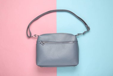 Pembe mavi pastel arka planda modaya uygun deri çanta. Üst görünüm