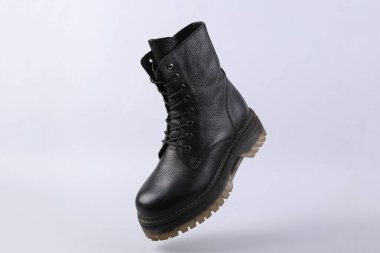 Gri arka planda deri çizmeler