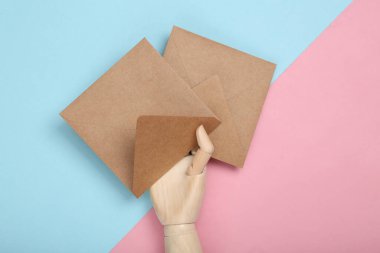 Ahşap el sanatları zarfları mavi-pembe pastel arka planda. Üst görünüm