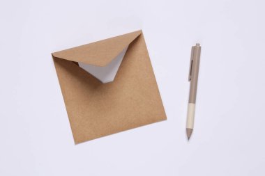 Beyaz arkaplanda mektup ve kalem olan el işi zarf. Üst görünüm