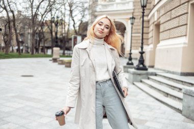 Şehirde dizüstü bilgisayarı ve kahvesi olan genç bir kız öğrenci.