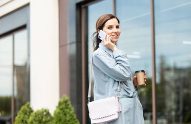 Telefonda konuşan ve şehirde kahve içen hoş bir kadın. Yaşam biçimi